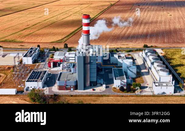 Aerial view of a power station chimney and cooling equipment. A red and ...