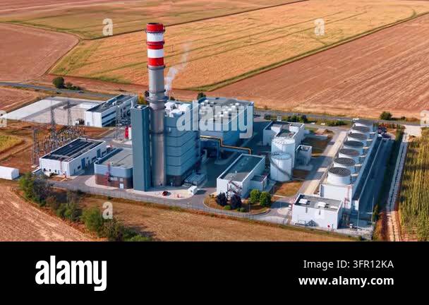 Power station buildings with a striped stack and cooling fan bank. Gray ...