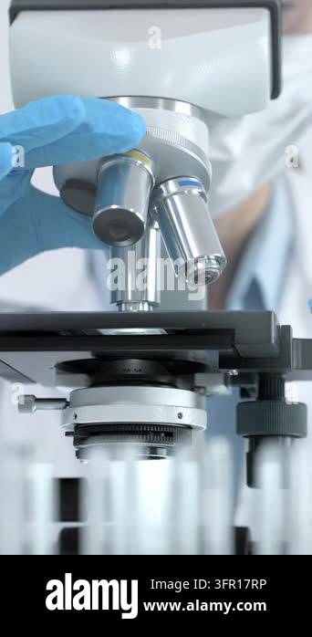 Objective Lens Model Scientist adjusting a microscope objective lens with gloved hands ...