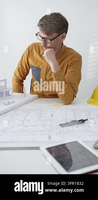 Architect in glasses working on a digital tablet at a modern office ...