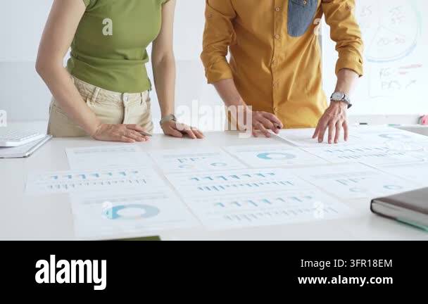 Two business professionals are collaborating on a project, analyzing ...