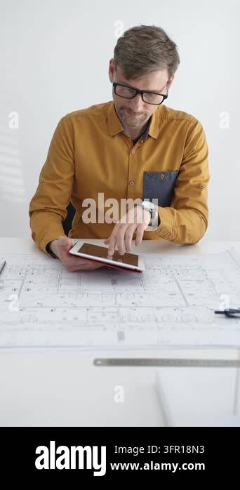 Architect in glasses working on a digital tablet at a modern office ...