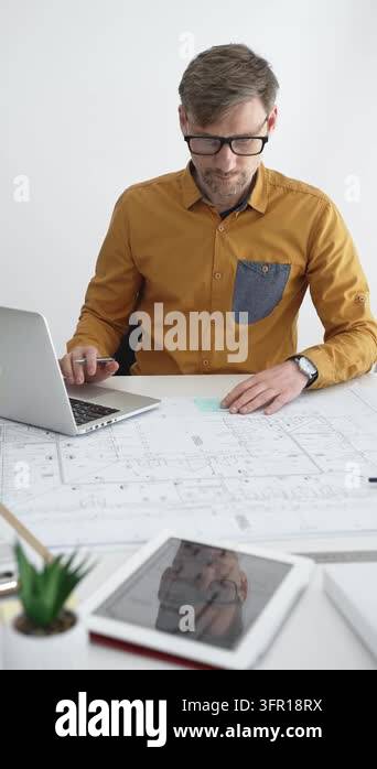 Architect in glasses working on a digital tablet at a modern office ...