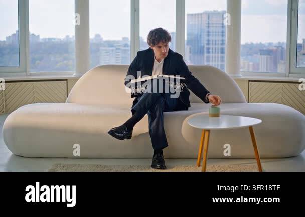 Successful businessman relaxing white sofa reading interior design book ...