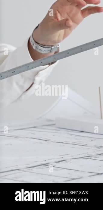 Architect working on detailed blueprints, designing a new building with ...