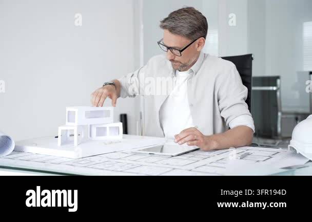 Architect creating building design, drafting blueprints, and developing ...