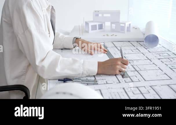 Architect hands using a compass and ruler on a detailed blueprint ...