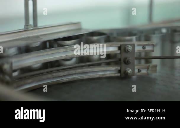 Empty glass jars traveling stainless steel conveyor factory. Closeup ...