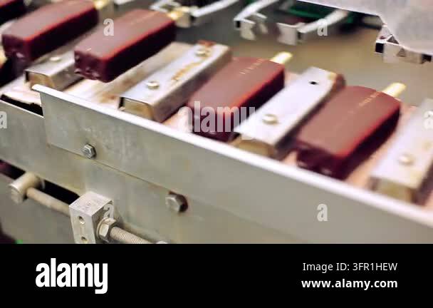 Conveyor carrying glazed popsicle bars closeup, food production line ...