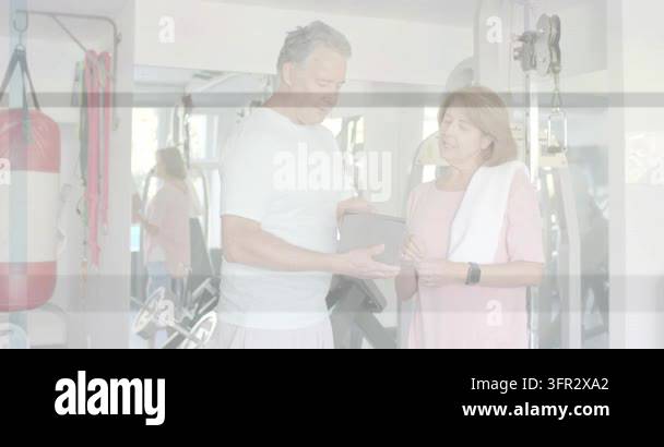 Vertical video: Male trainer opening tablet and gesturing in gym ...