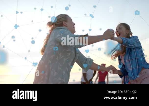 Two women leaning grasping hands dancing on sunset beach having fun ...