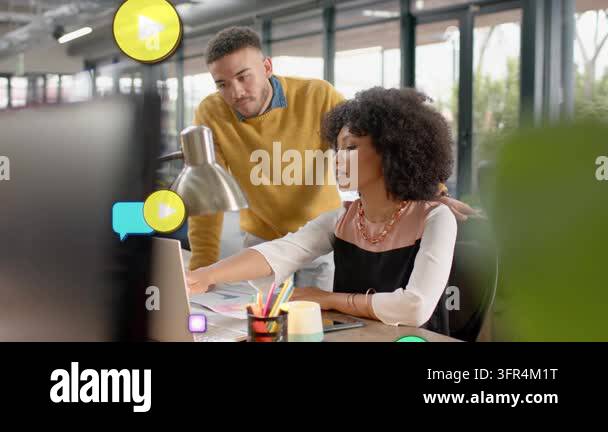 Woman clicking mouse, man leaning in, reviewing marketing while icons ...