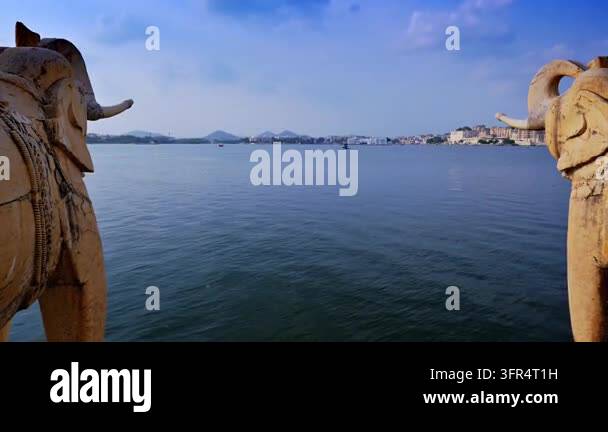 Carved elephant statues at Jag Mandir frame a view across Lake Pichola ...