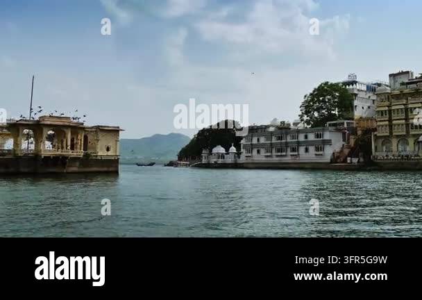 An arched pavilion and white waterfront buildings frame open water and ...