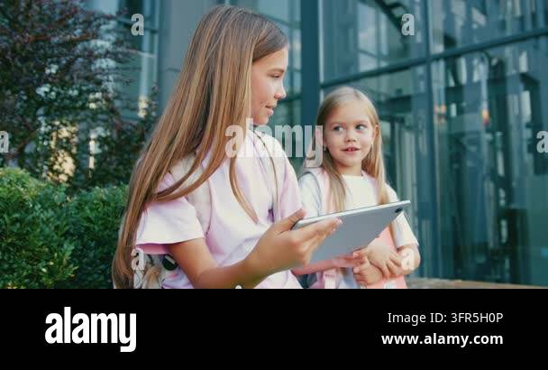Little Learning Two school little children pupils girl sisters sitting on stairs street ...
