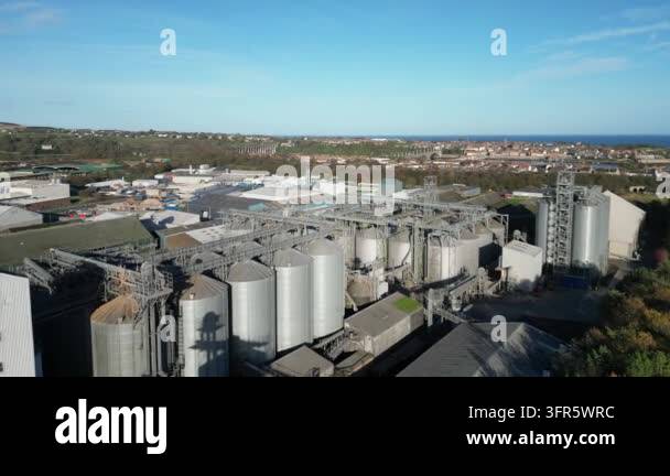 Industrial complex showcasing large silos against clear blue sky Stock ...