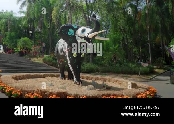 Black elephant sculpture dressed in skeleton costume surrounded by ...