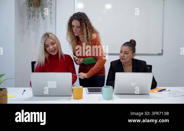 Diverse team of professional women collaborating on a project in a ...