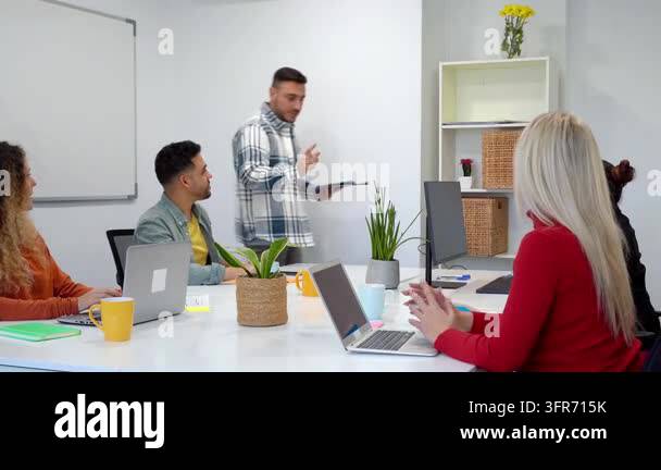 Young business manager giving a presentation to colleagues in a modern ...