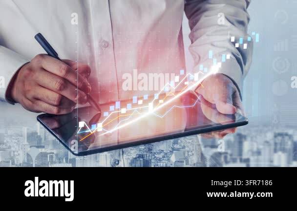A business professional using a digital tablet to analyze financial ...
