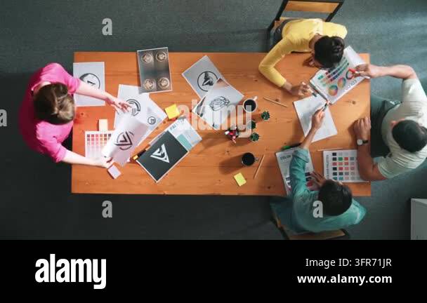 Top down aerial view of designer looking at tablet while project ...