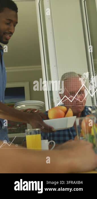 Vertical video: Standing man placing plates meal while senior watching ...