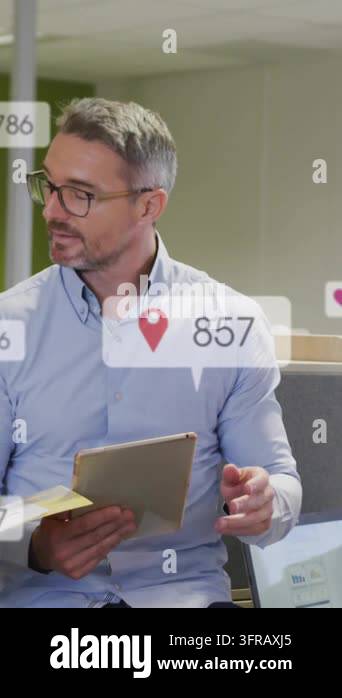 Vertical video: Man tapping tablet and docs, updating icon badges for ...