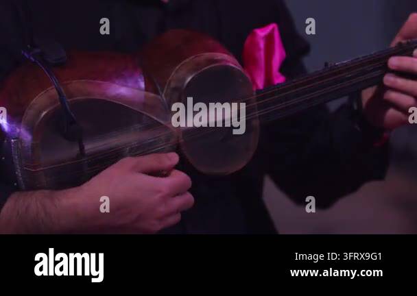 String Instruments Hd Person holding a traditional string instrument with a visible bow in a ...