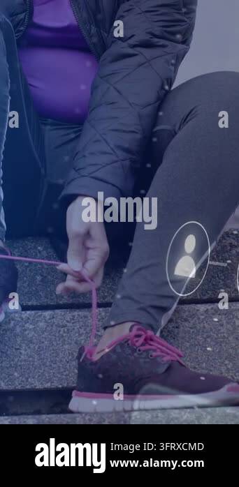 Vertical video: Woman reaching pink lace, threading, tying sneaker ...