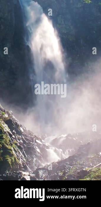 Waterfall spray illuminated by bright sunlight. Waterfall mist above a ...