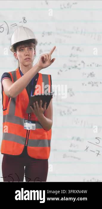 Vertical video: Checking tablet, worker in hi-vis helmet pointing ...