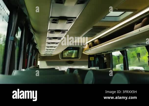 Modern intercity bus interior with passenger seats and overhead luggage ...