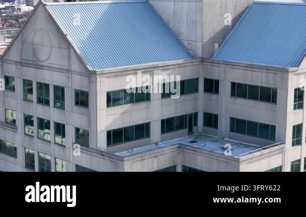 Close-up view of building exterior with a sloped roof and large windows ...