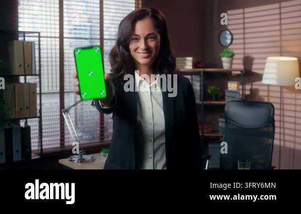 Smiling Caucasian business woman showing thumb up and mobile phone ...