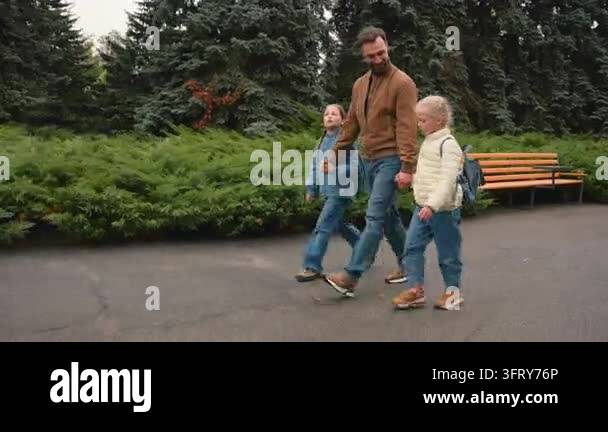Happy Caucasian family walking back to school. Caring father walk with ...