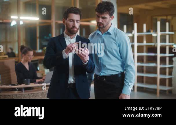 Two satisfied Caucasian business men using mobile phone showing chroma ...