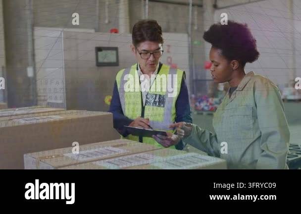 Two warehouse staff tapping tablet and scanning labels, causing graph ...