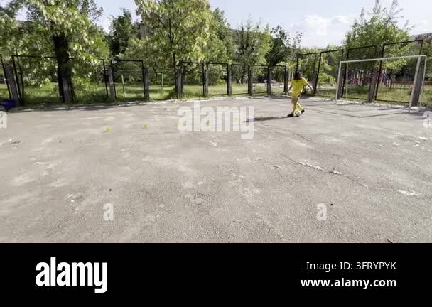 Teen boy training football skills controlling ball with feet and moving ...