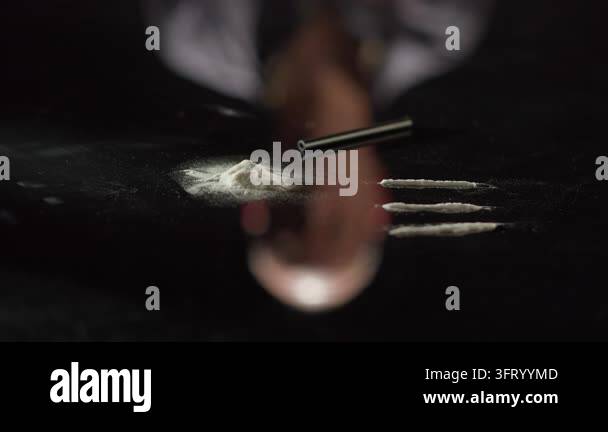 Close-up of cocaine on a glossy black table, with the inverted ...