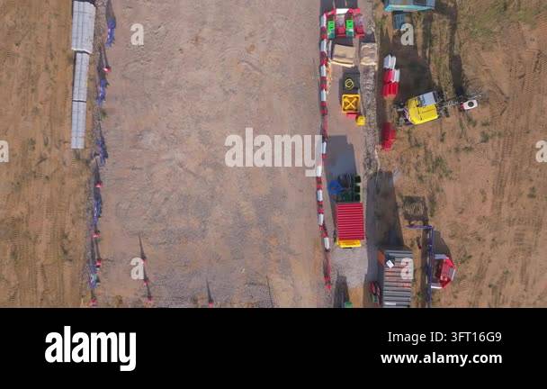 A top down rising drone view of the site compound construction area for ...