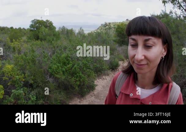 A beautiful young, happy adult girl was hiking with a backpack in the ...
