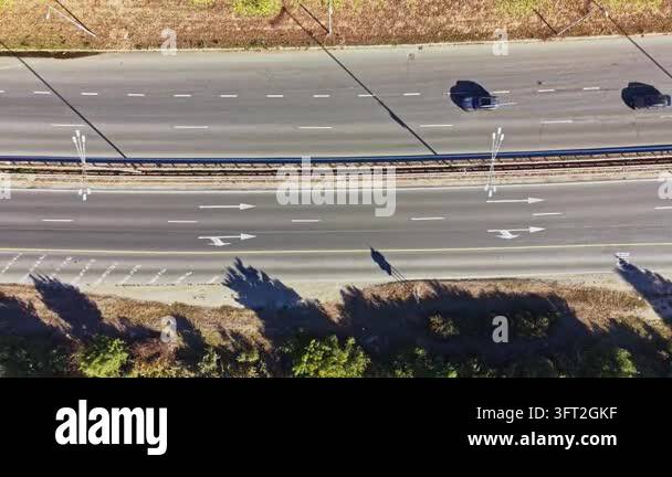 Cars move along a highway seen from above. The scene shows clear lanes ...