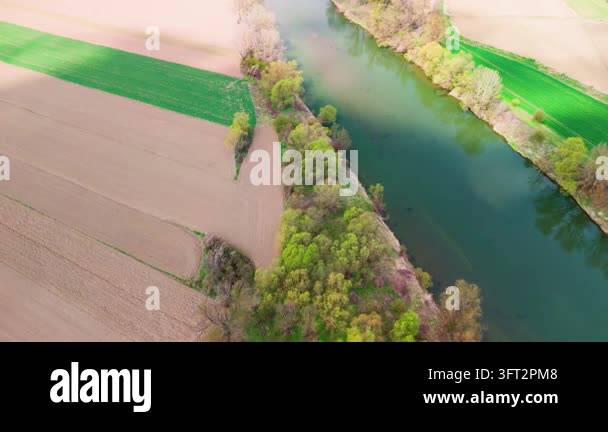 Aerial Spring Aerial view down a calm river channel lined with spring trees, a bright ...