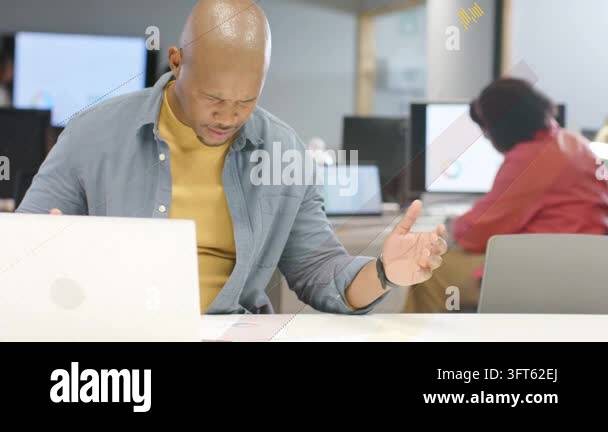 Man reacting to new laptop data, lifting printout, consulting coworker ...