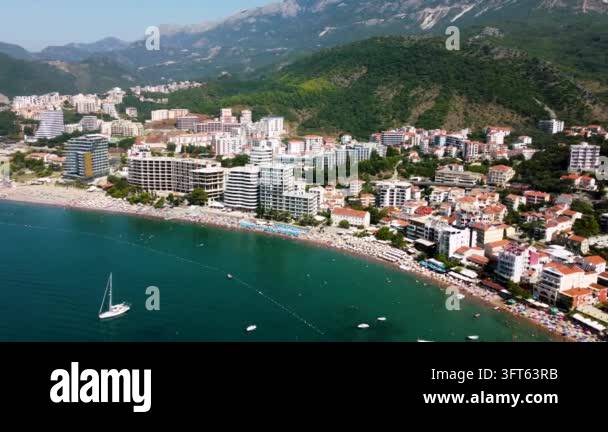 Aerial view of a crowded beach and coastal city with mountains in the ...
