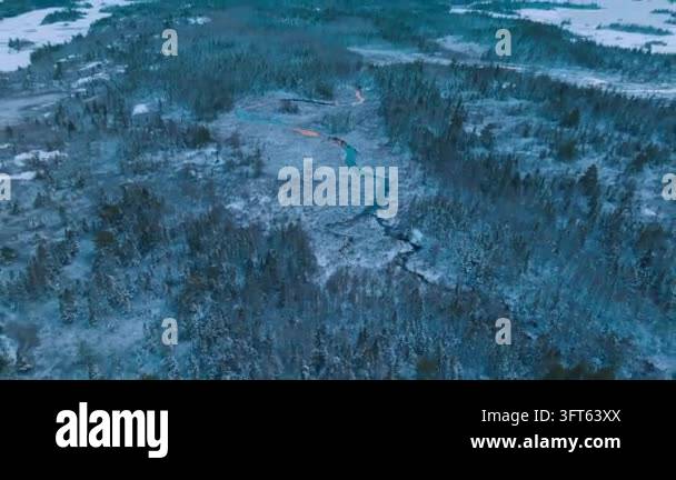 Winding Riger Aerial view of winding river through snow covered forest during ...