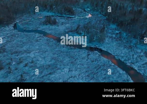 Winding Riger Aerial view of a winding river flowing through a snow covered forest at ...