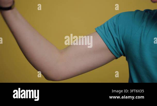 A man showcases his muscular arm against a vibrant yellow background ...