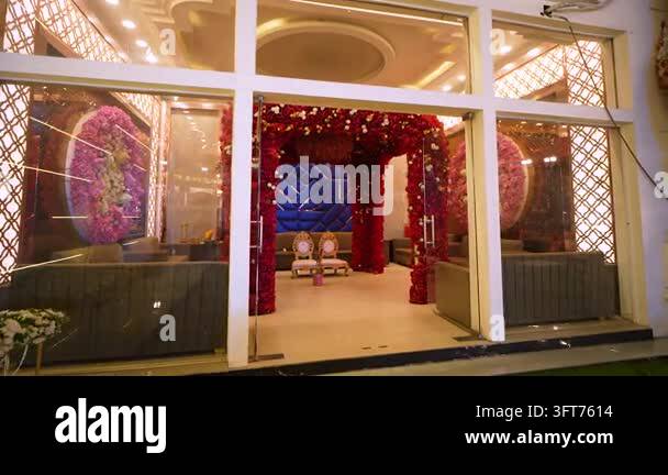 Red Indiand A festive Indian wedding venue setup featuring a red floral arch and ...