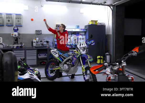 Kyiv, Ukraine, 5 June 2026 : Man adjusts gear in garage workspace. Two ...